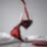 A vibrant red wine glass spilling liquid onto a pristine white fabric.